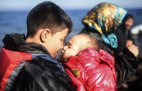 A youth embraces his sibling as refugees and migrants reach the shores of the Greek island of Lesbos after crossing the Aegean Sea from Turkey on November 12, 2015. EU leaders attending a summit with their African counterparts approved a 1.8-billion-euro trust fund for Africa aimed at tackling the root causes of mass migration to Europe. AFP PHOTO / BULENT KILIC (Photo credit should read BULENT KILIC/AFP/Getty Images)