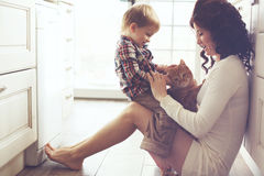 mother-child-playing-cat-her-baby-pet-floor-kitchen-home-49928308