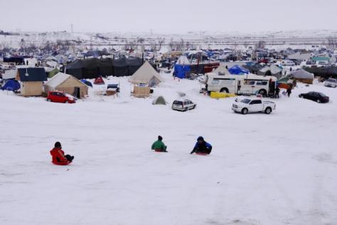 Children sled down a hill inside of the Oceti Sakowin camp as "water protectors" continue to demonstrate against plans to pass the Dakota Access pipeline near the Standing Rock Indian Reservation, near Cannon Ball, North Dakota, U.S., December 2, 2016. REUTERS/Lucas Jackson