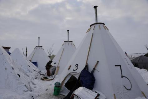 A camper works on her tent inside of the Oceti Sakowin camp as "water protectors" continue to demonstrate against plans to pass the Dakota Access pipeline near the Standing Rock Indian Reservation, near Cannon Ball, North Dakota, U.S., December 2, 2016. REUTERS/Lucas Jackson