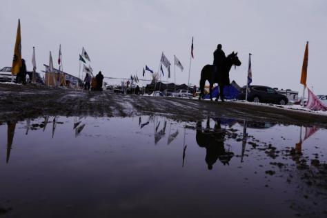 A man rides a horse down a road inside of the Oceti Sakowin camp as "water protectors" continue to demonstrate against plans to pass the Dakota Access pipeline near the Standing Rock Indian Reservation, near Cannon Ball, North Dakota, U.S., December 2, 2016. REUTERS/Lucas Jackson