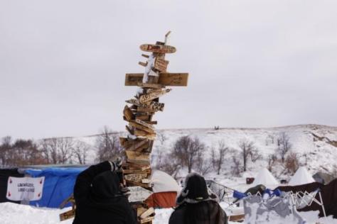 Campers photograph a signpost with the names of various tribes on it inside of the Oceti Sakowin camp as "water protectors" continue to demonstrate against plans to pass the Dakota Access pipeline near the Standing Rock Indian Reservation, near Cannon Ball, North Dakota, U.S., December 2, 2016. REUTERS/Lucas Jackson