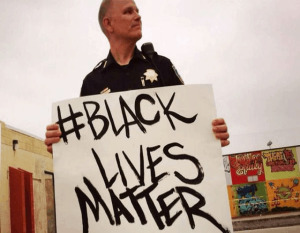 6360388961552704001704709008_policechiefchrismagnusholdingupblacklivesmatterprotestsignposterartwork-1