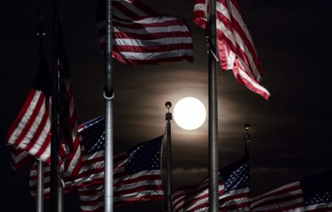 The full moon rises above the flags at the Washington Monument on Monday, June 20. June's full moon, also known as the Strawberry Moon, coincided with the summer solstice for the first time since the Summer of Love in 1967. Getty