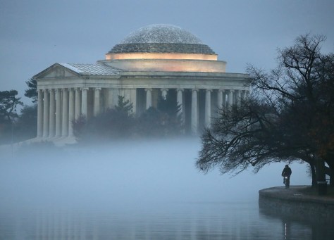 The Jefferson Memorial is surrounded in fog as a man rides a bicycle along the Tidal Basin, on November 30. Getty